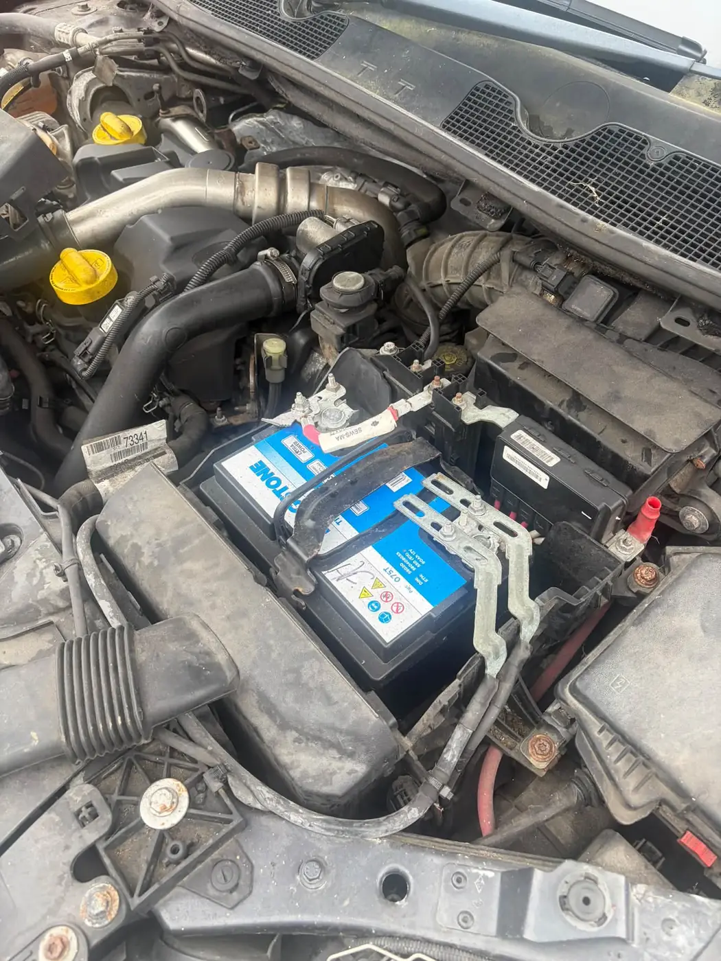 The new blue and white battery fitted and clamped in the same engine bay
